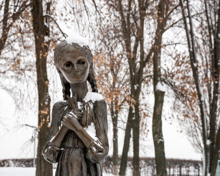 Kyiv, Ukraine - JAN 2019: Close-up of child holding spikelet monument in front of National Museum of Holodomor Genocide also known as Memorial in Commemoration of famine victims of 1923-1933 years