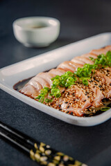 Blowtorcherd salmon sashimi with passion fruit sauce.