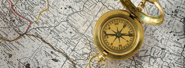 Retro styled golden compass (sundial) and old white nautical chart close-up. Vintage still life. Sailing accessories. Travel and navigation theme - Powered by Adobe