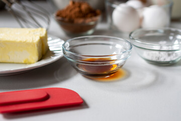 Side view of baking ingredients.  Ingredients include: egg, butter, vanilla, cocoa, and baking powder.