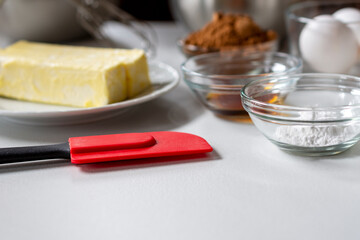 Side view of baking ingredients.  Ingredients include: egg, butter, vanilla, cocoa, and baking powder.