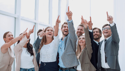 group of confident young people, pointing somewhere up.