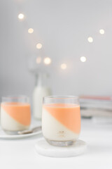 Vanilla and orange creamsicle panna cotta, panna cotta served in a glass cup, cooked cream in a glass cup, coral panna cotta dessert - obrazy, fototapety, plakaty