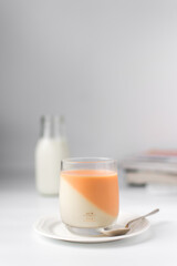 Vanilla and orange creamsicle panna cotta, panna cotta served in a glass cup, cooked cream in a glass cup, coral panna cotta dessert