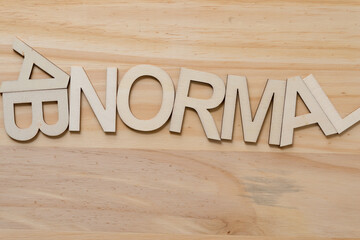 the letters AB and the word "NORMAL" in all caps on wood