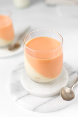 Vanilla and orange creamsicle panna cotta, panna cotta served in a glass cup, cooked cream in a glass cup, coral panna cotta dessert