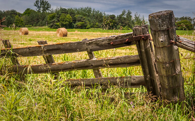 A broken wood gate at  the entrance to a  farm field in Stouffville Canada.