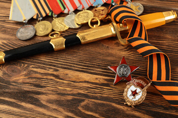 Orders and medals of the veteran on the St. George ribbon. MAY 9 greeting card. Wooden background.