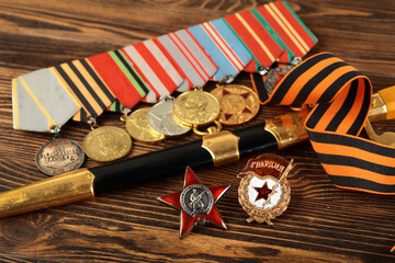 Orders and medals of the veteran on the St. George ribbon. MAY 9 greeting card. Wooden background.