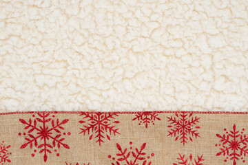 Red and brown snowflake border winter background on beige sherpa material