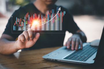 The concept of stock market investment, business growth, progress and success A businessman sat on his desk showing more and more Grammy stocks on a virtual screen, investing in trade profits.