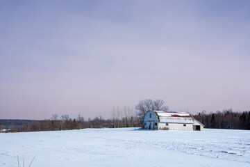 Old barn in a winter countryside landscape in Quebec, Canada