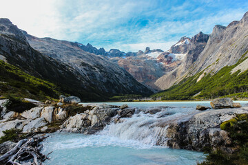 Pequeña cascada en lago turquesa entre montañas