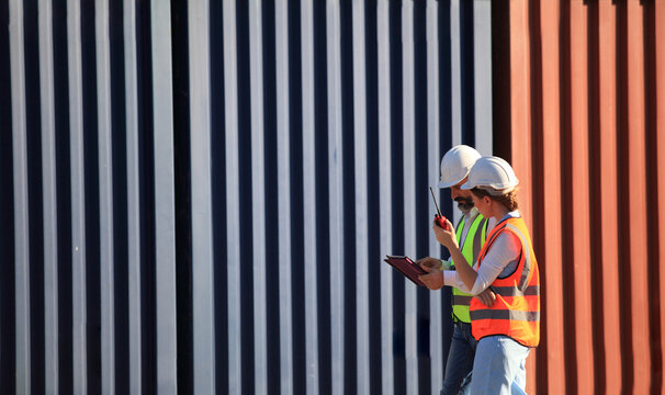 team engineer he is working in container box yard area of  logistics transportation import export or shipping industry