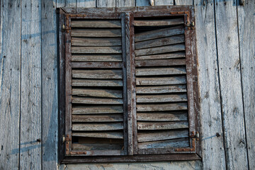 Sunja, Croatia, 05,04,2021: Rustic style aged window in wooden village rural home wall.