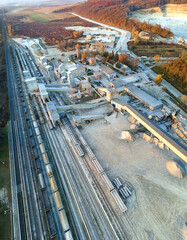 Aerial view of cargo train loaded with crushed stone materials at mining factory. Railway...