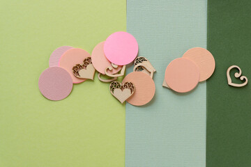 paper circles and wooden heart shapes on green