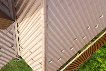 House roof structure covered with brown metal tile sheets.