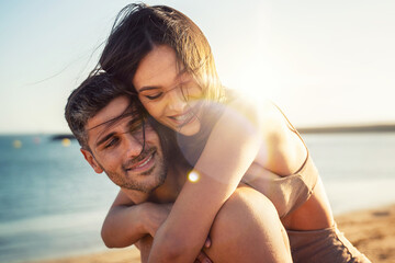 Portrait of lovely couple in love having fun on the beach. Young beautiful people hugging ....