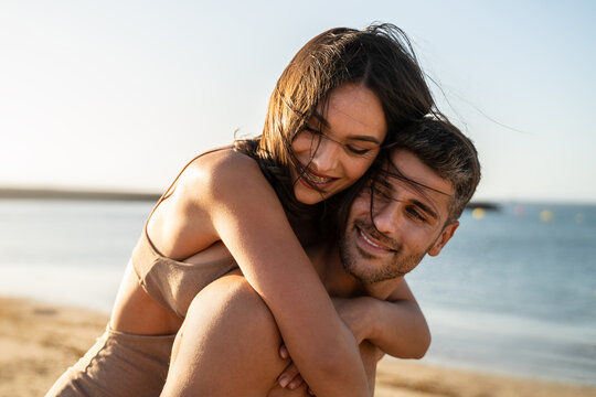 Portrait of lovely couple in love having fun on the beach. Young beautiful people hugging . Romantic moment. Valentine's day.