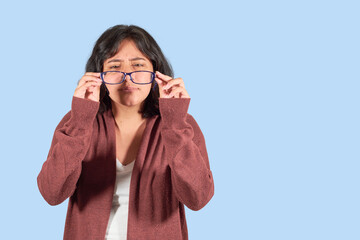 Young Latin woman with glasses straining his eyes because he can't see well. Isolated.