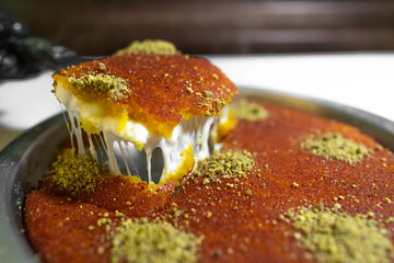 Arabic traditional dessert - kunafa - konafa in a tray with pistachio - creative delicious middle...