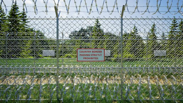 Country border sign. Passing is strictly prohibited. Boundary fence. Migration