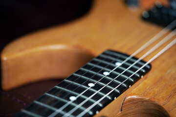 Fototapeta premium Guitar wallpaper. Musical instrument. Performance. Art. Strings. Electric guitar closeup detail. Music. Play. Wooden vintage guitar. Ukulele 