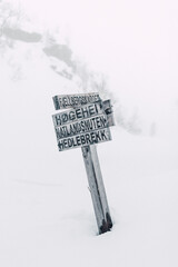 Directional sign post in snow in Norwegian