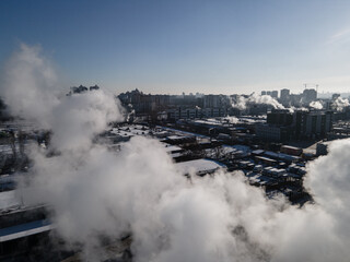 Aerial view from a drone to the factory and to air pollution in the city
