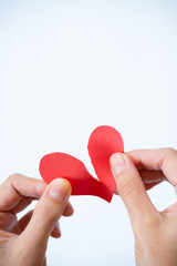 Vertical shot two hands breaking a heart