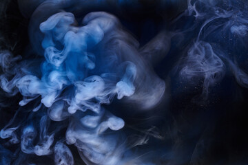 Blue smoke on black ink background, colorful fog, abstract swirling ocean sea, acrylic paint pigment underwater