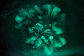 Green smoke on black ink background, colorful fog, abstract swirling emerald ocean sea, acrylic paint pigment underwater