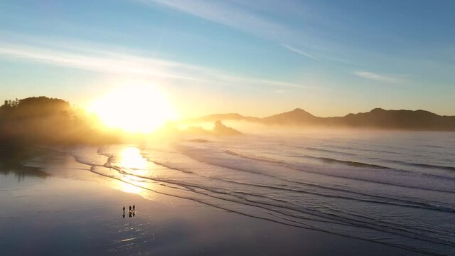 Dramatic Aerial Sunrise Scene At The Beach With People Walking