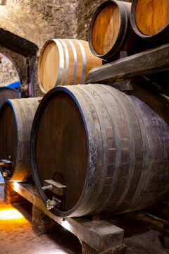 Medieval Underground Wine Cellars With Old Red Wine Barrels For Aging Of Vino Nobile Di Montepulciano In Old Town Montepulciano In Tuscany, Italy