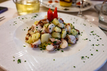 Tasty seafood salad with boiled octopus, potatoes, olive oil parsley served in Italian restaurant