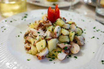 Tasty seafood salad with boiled octopus, potatoes, olive oil parsley served in Italian restaurant