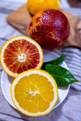 Sicilian sweet juicy yellow and red blood oranges with green leaves close up