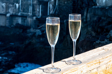 New year celebration with two glasses of champagne or Spanish cava sparkling wine and view on black lava rocks, Canary islands, winter tourists destination