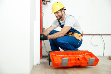 Hardworking technician, plumber in uniform using tools from toolbox while installing and checking...