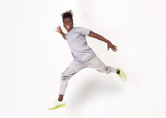 Happy young smiling excited afro man jumping in front of a white or grey background. Hight Quality...