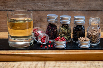 Professional set of gin spices in small bottles, pink pepper, hibiscus flowers, juniper berries, cardamom and coriander seeds