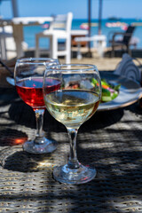 Drinking of cold rose and white wines in lounge bar on sunny sandy beach with blue sea water on background