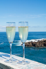 New year celebration with two glasses of champagne or Spanish cava sparkling wine and view on blue Atlantic ocean, Canary islands, winter tourists destination