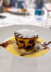 Tasty Italian dessert, small hot cake with chocolate and white gravy on white plate