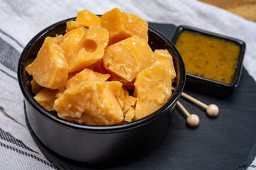 Cheese tasting, small pieces of old Dutch hard cheese and bowl with homemade dill-mustard sauce