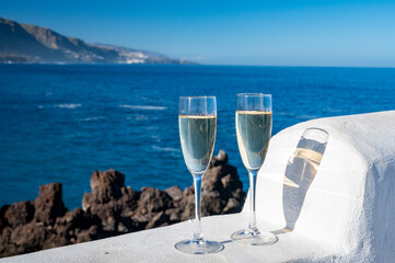 New year celebration with two glasses of champagne or Spanish cava sparkling wine and view on blue Atlantic ocean, Canary islands, winter tourists destination