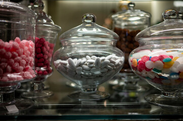 Candy shop display with glass jars filled with jelly candies and bonbons