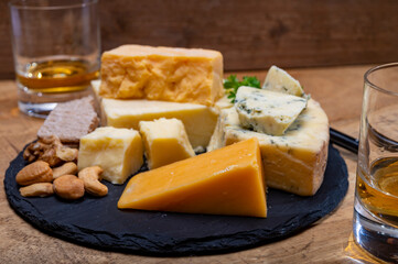 British drinks and food, glasses of Scotch whisky and cheeses collection, blue Stilton, Scottish coloured and English matured cheddar cheeses