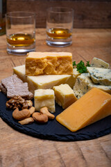 British drinks and food, glasses of Scotch whisky and cheeses collection, blue Stilton, Scottish coloured and English matured cheddar cheeses